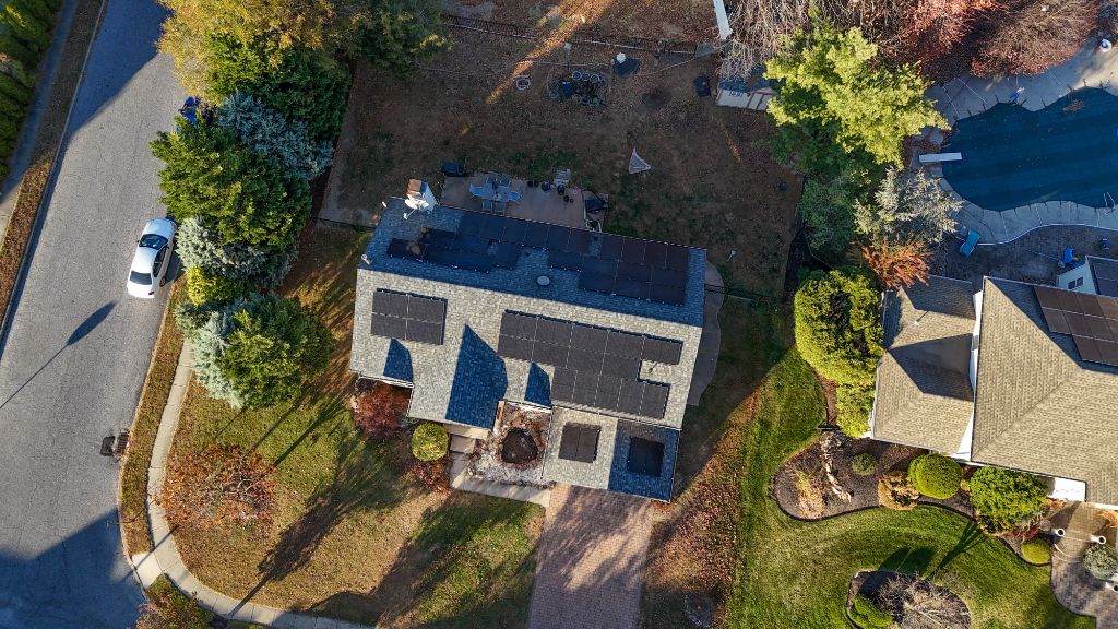 Aerial view of a home with solar panels installed across the roofline