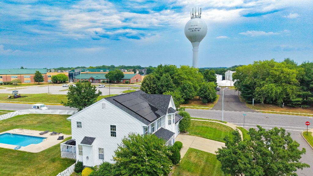 Aerial view of a Velocity Energy roof and solar project near a municipal water tower
